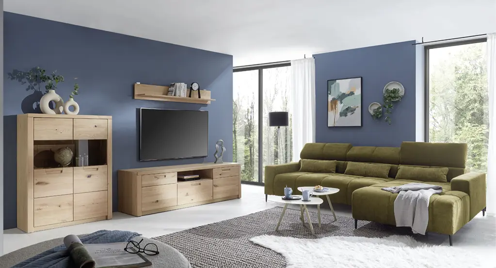 Wohnzimmer mit TV-Möbeln aus Holz, grünem Sofa, Teppich und großer Fensterfront